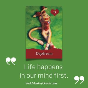 Shannon Grissom's painting of a Sock Monkey Daydreaming in the grass with the text "Daydream. Life happens in our mind first."