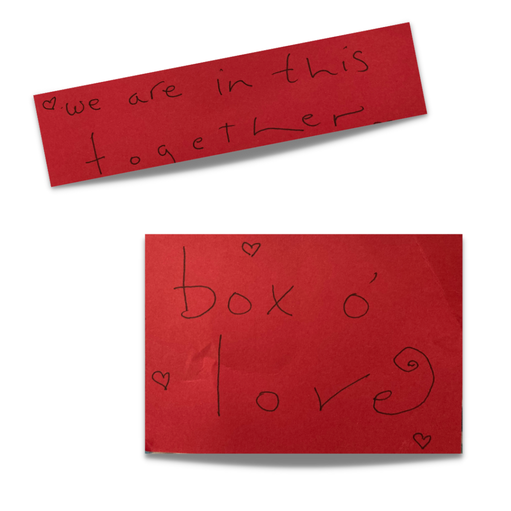 Red paper, handwritten notes: "We are all in this together" and "box o love" with hearts