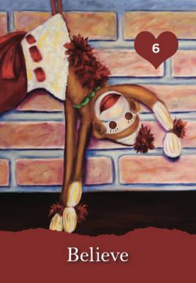 Sock Monkey hanging upside down in Christmas stocking in front of fireplace